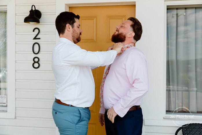 Groom getting ready outside of motel room. Photographe de mariage au Saguenay. Photographe Saguenay-Lac-Saint-Jean. Auberge Le Parasol. Saguenay wedding photographer.
