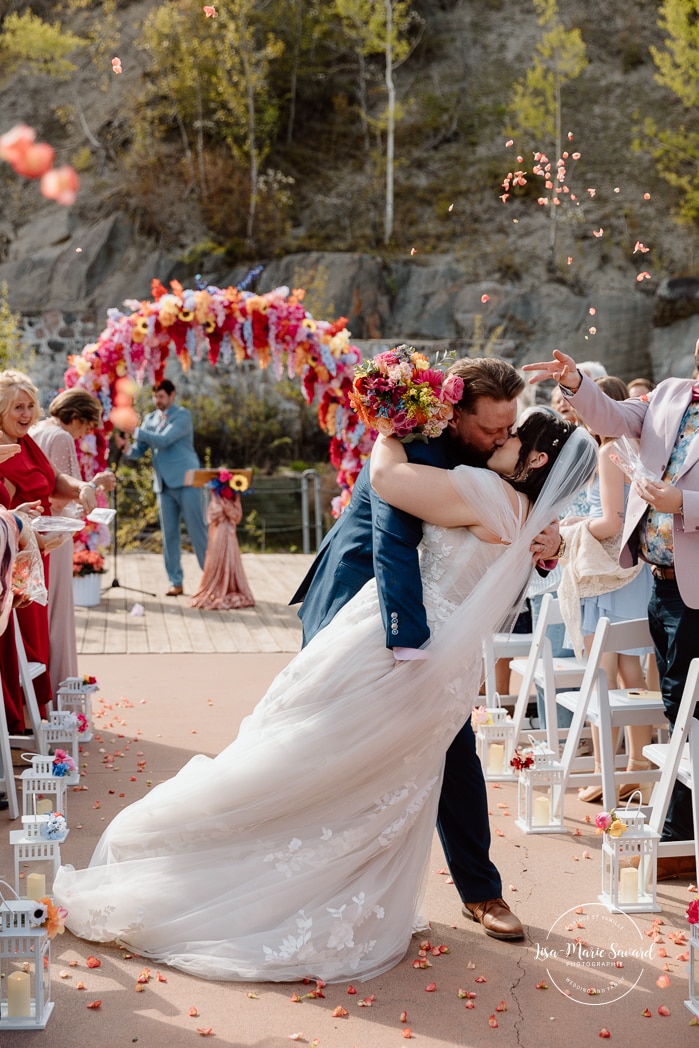 Outdoor wedding ceremony with floral arch. Colorful wedding ideas. Photographe de mariage au Saguenay. Photographe Saguenay-Lac-Saint-Jean. Mariage Pulperie de Chicoutimi. Jardin des Vestiges. Bâtiment 1912. Saguenay wedding photographer.