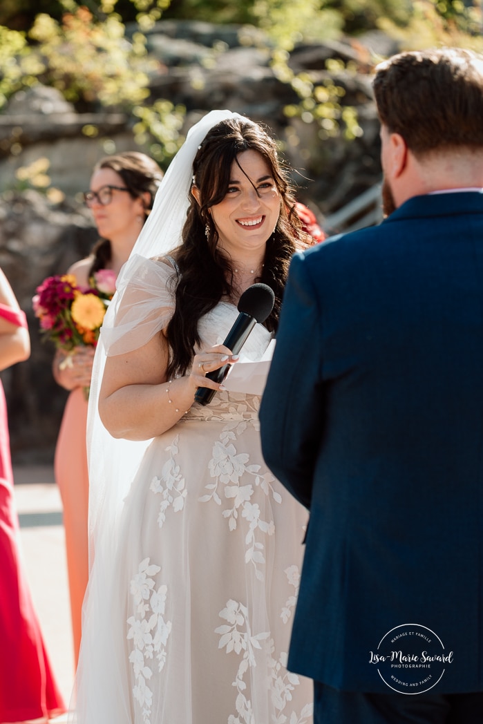Outdoor wedding ceremony with floral arch. Colorful wedding ideas. Photographe de mariage au Saguenay. Photographe Saguenay-Lac-Saint-Jean. Mariage Pulperie de Chicoutimi. Jardin des Vestiges. Bâtiment 1912. Saguenay wedding photographer.
