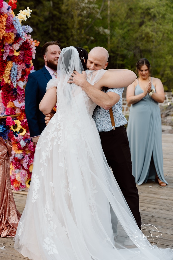 Outdoor wedding ceremony with floral arch. Colorful wedding ideas. Photographe de mariage au Saguenay. Photographe Saguenay-Lac-Saint-Jean. Mariage Pulperie de Chicoutimi. Jardin des Vestiges. Bâtiment 1912. Saguenay wedding photographer.