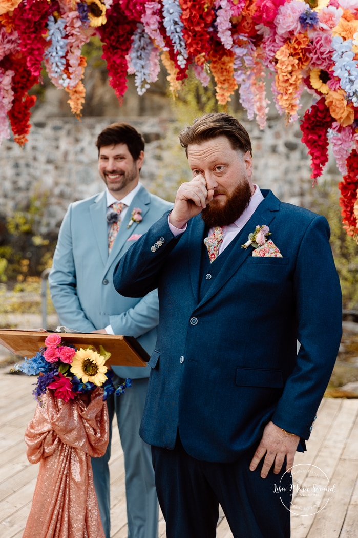 Outdoor wedding ceremony with floral arch. Colorful wedding ideas. Photographe de mariage au Saguenay. Photographe Saguenay-Lac-Saint-Jean. Mariage Pulperie de Chicoutimi. Jardin des Vestiges. Bâtiment 1912. Saguenay wedding photographer.
