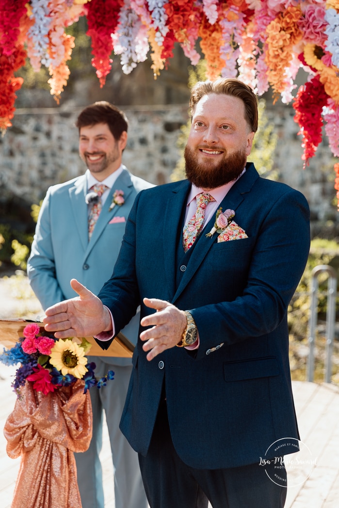 Outdoor wedding ceremony with floral arch. Colorful wedding ideas. Photographe de mariage au Saguenay. Photographe Saguenay-Lac-Saint-Jean. Mariage Pulperie de Chicoutimi. Jardin des Vestiges. Bâtiment 1912. Saguenay wedding photographer.