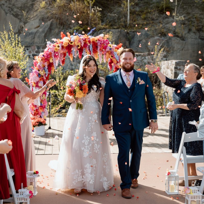 Outdoor wedding ceremony with floral arch. Colorful wedding ideas. Photographe de mariage au Saguenay. Photographe Saguenay-Lac-Saint-Jean. Mariage Pulperie de Chicoutimi. Jardin des Vestiges. Bâtiment 1912. Saguenay wedding photographer.